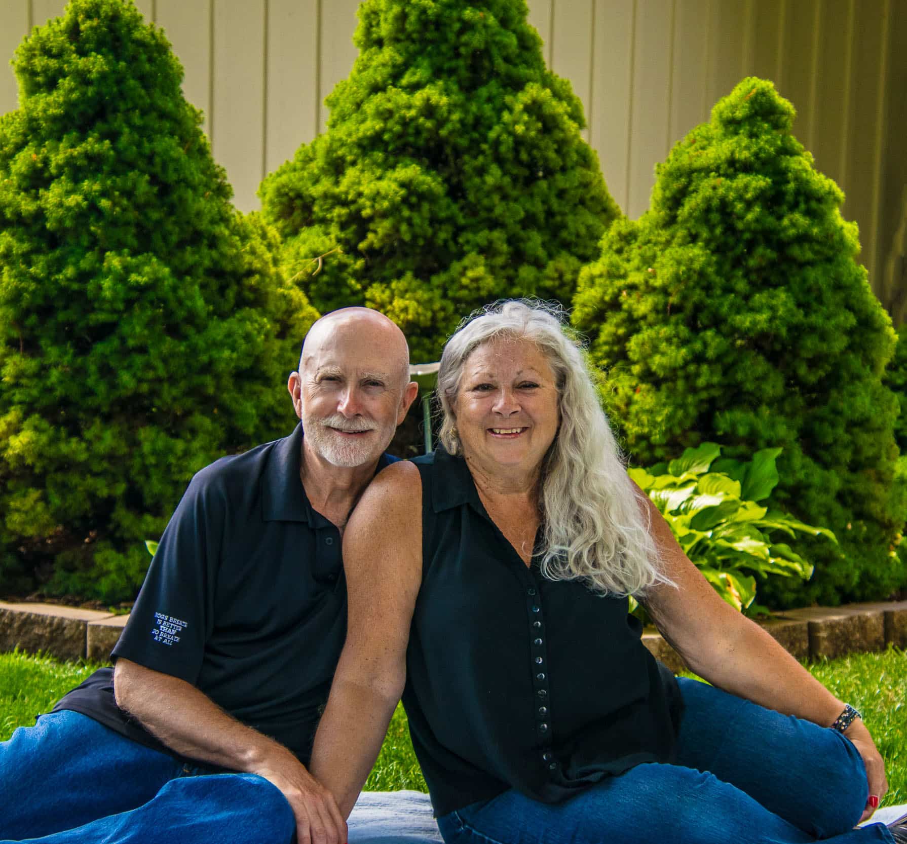 man and woman posing for picture in backyard